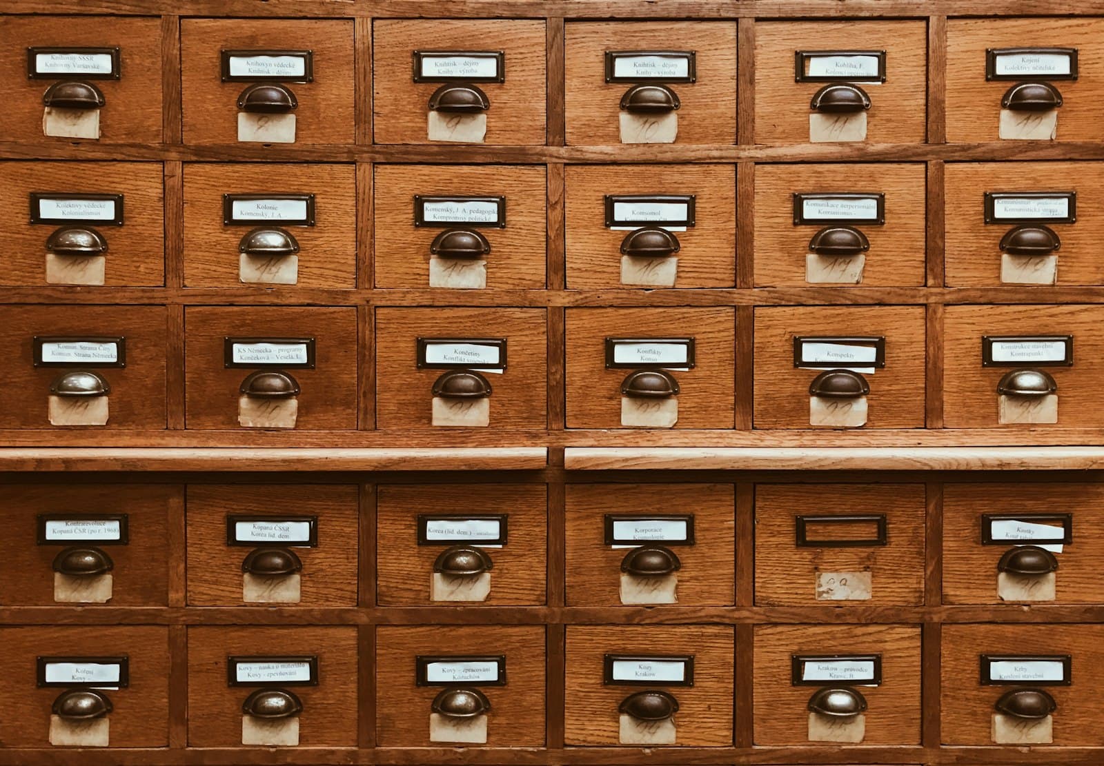 Rows of labeled wooden card-catalog drawers