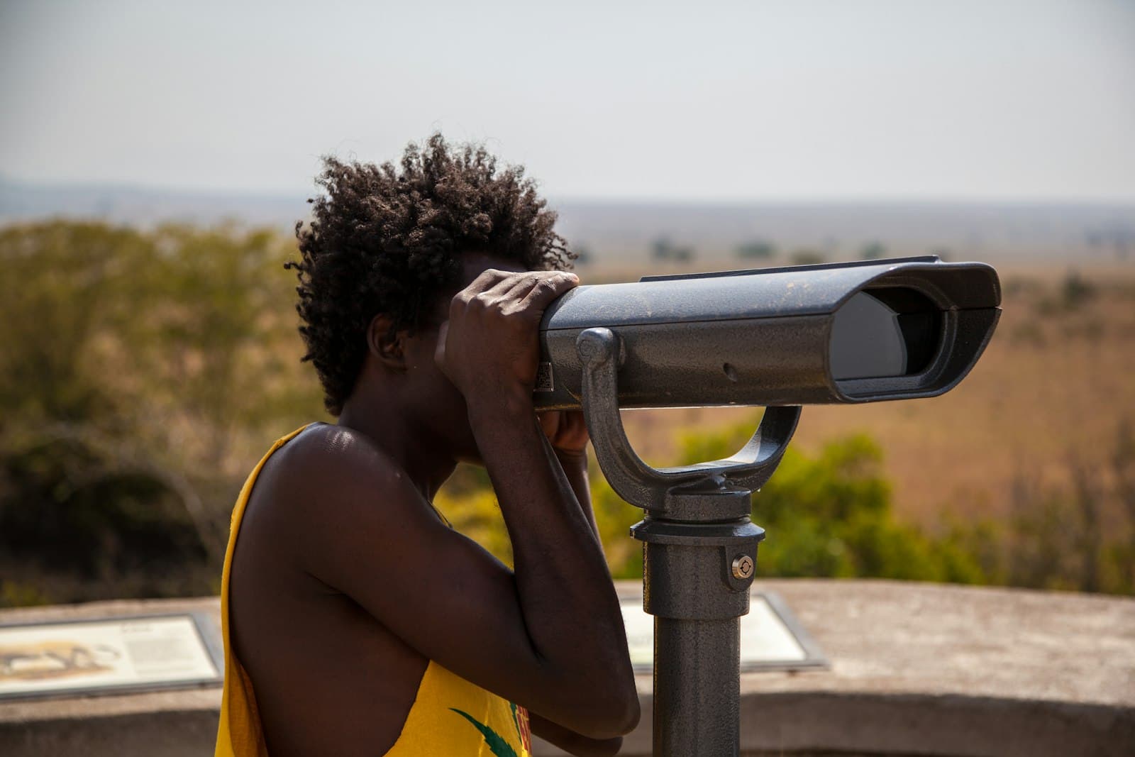 A person scanning the horizon through a mounted viewpoint telescope