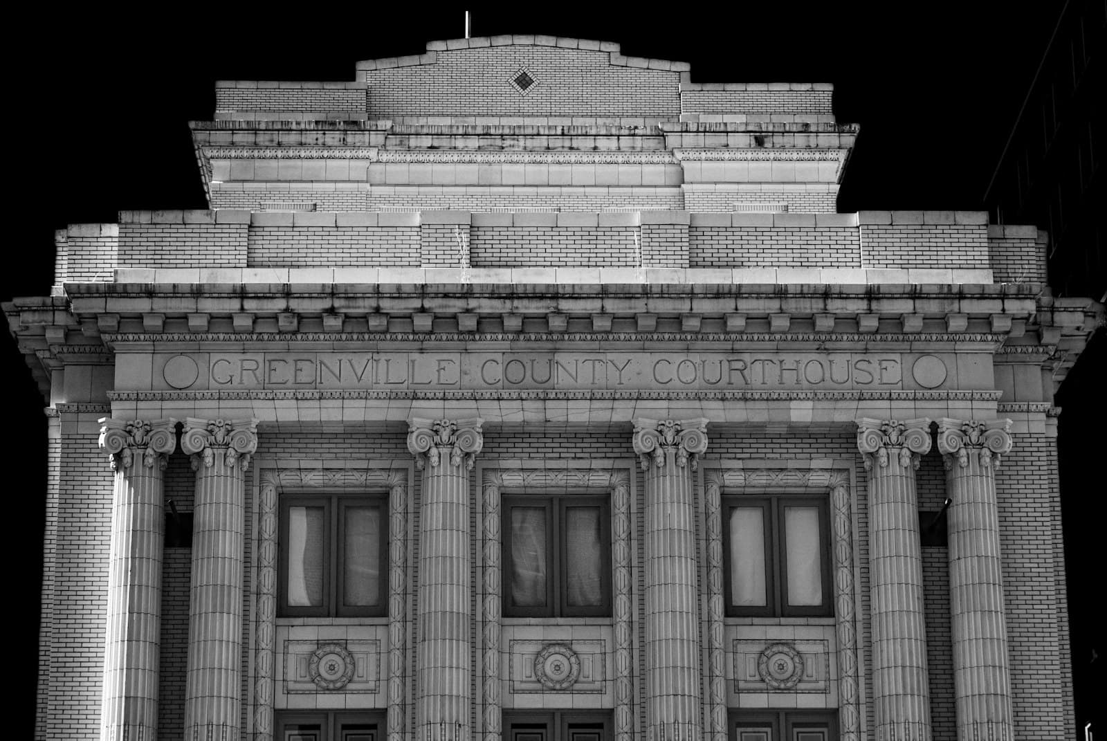 The classical stone facade of a county courthouse with tall columns