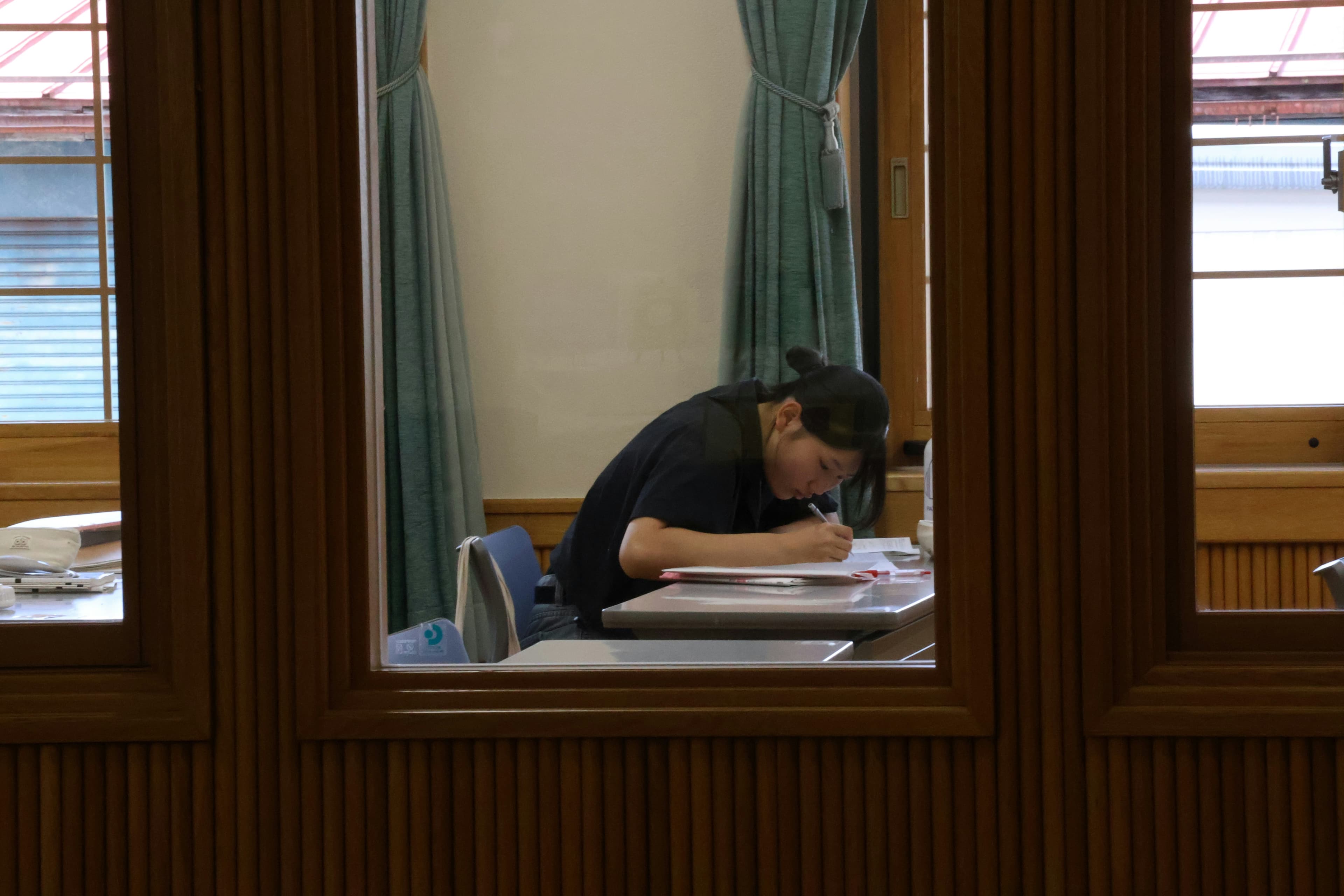 A lone worker leans over their desk in quiet concentration.