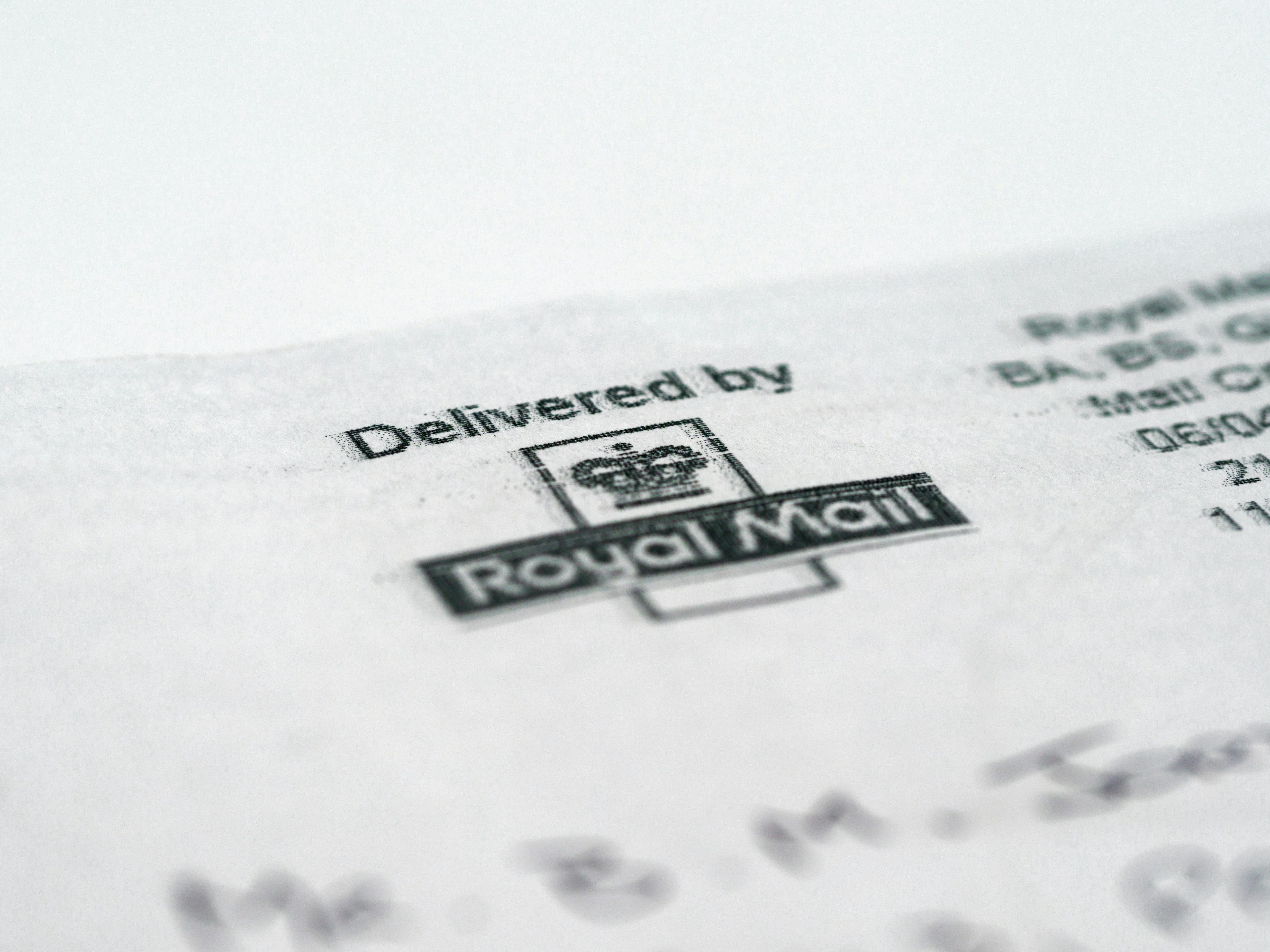 Macro shot of a white envelope showing a Delivered by Royal Mail stamp.
